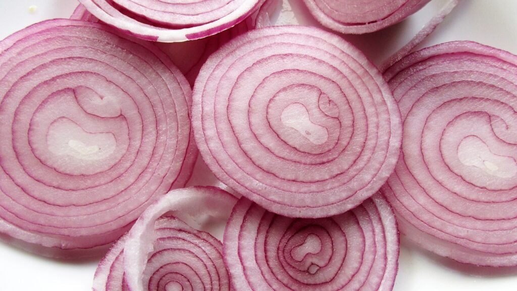 Sliced red onions with visible concentric rings in shades of pink and purple.